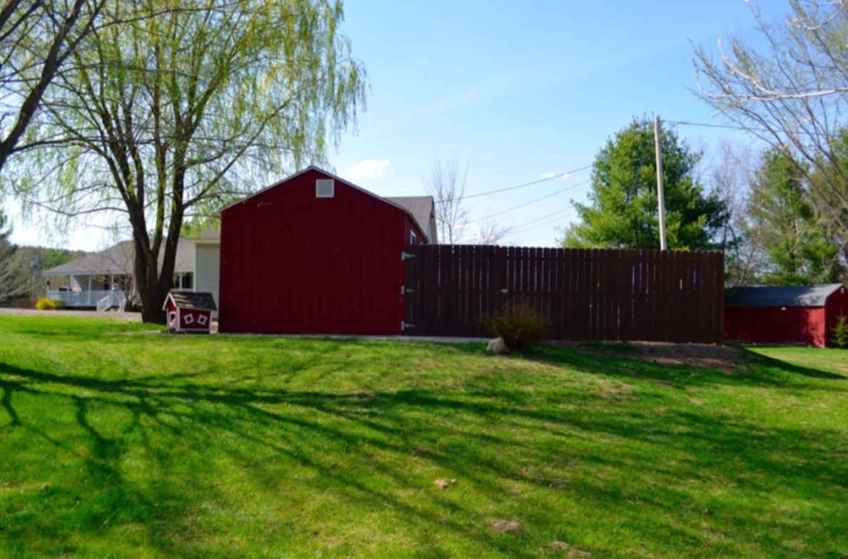 Red barn on green grassy field.